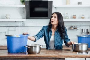 confused brunette woman dealing with water damage PVFAXS6 1